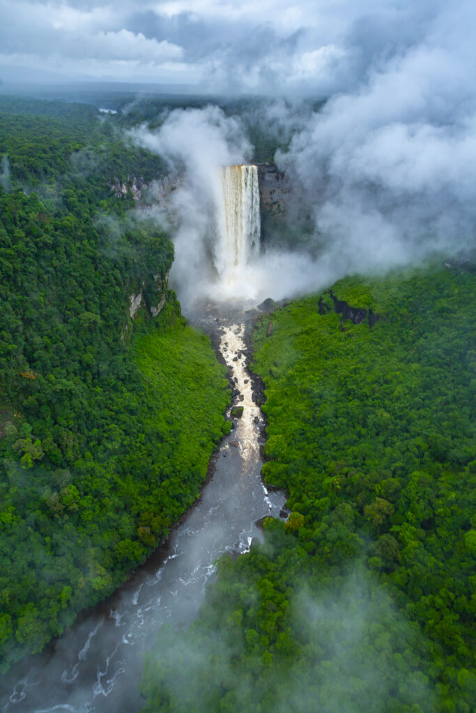 Aerial shot of Kaieteur Falls on the Potaro River with a cloud of spray rising, Kaieteur National Park, Potaro-Siparuni region, Essequibo territory, Guyana. Kaieteur Falls are considered the largest single-drop waterfall in the world. The Essequibo region is the subject of a dispute between Guyana and Venezuela.